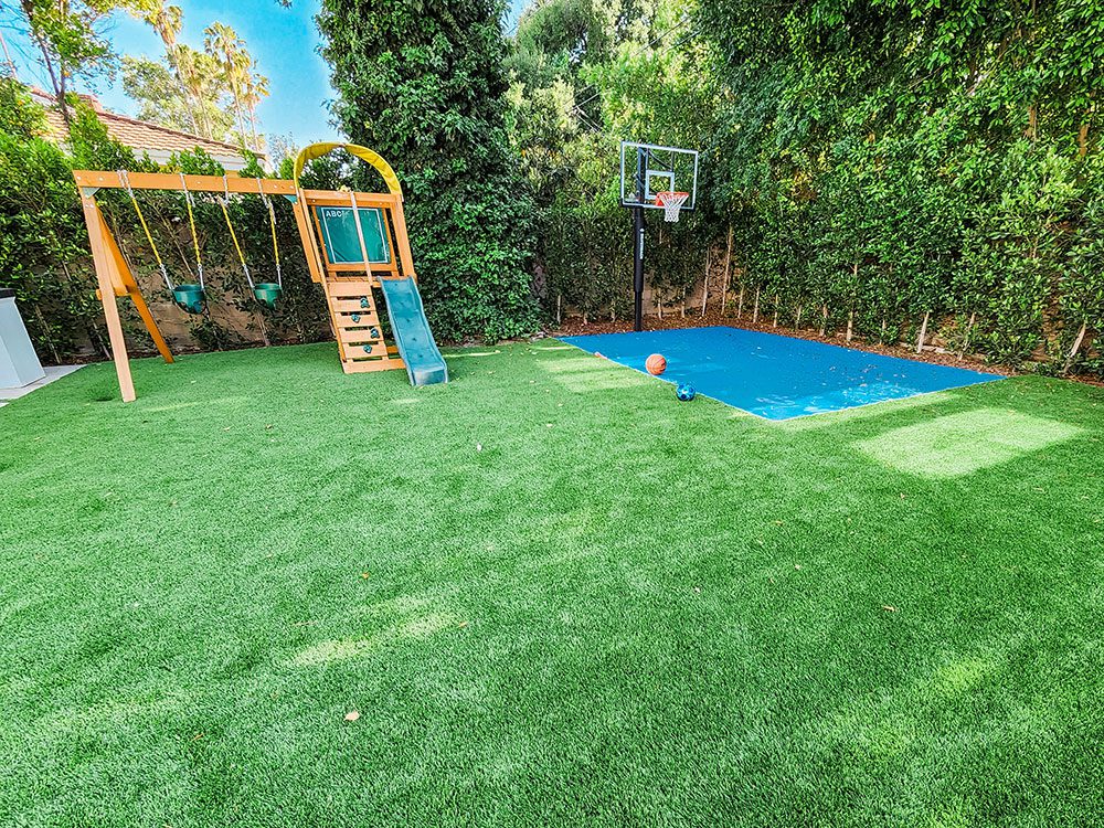 Playground and basketball hoop on synthetic grass