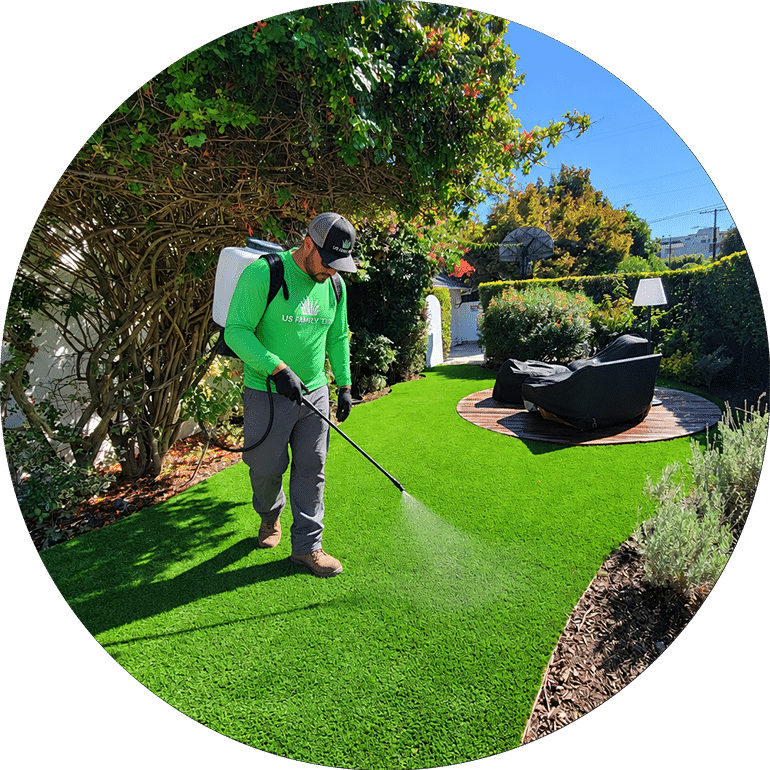 US Family Turf technician applying cleaning treatment to artificial turf
