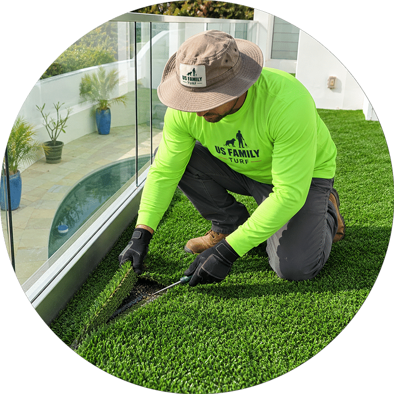 US Family Turf technician inspecting artificial turf infill and edge condition